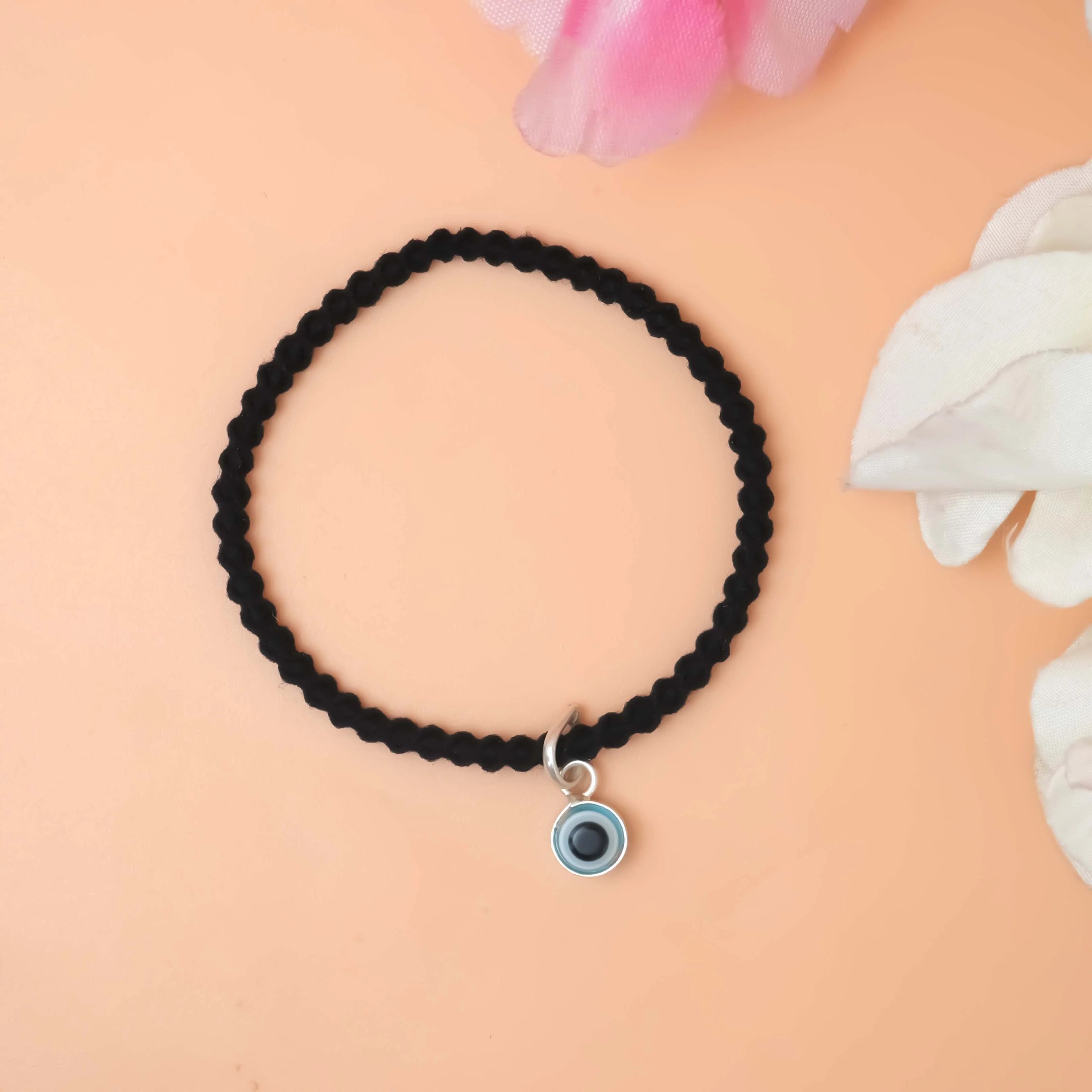 A stylish black bracelet featuring a silver evil eye charm